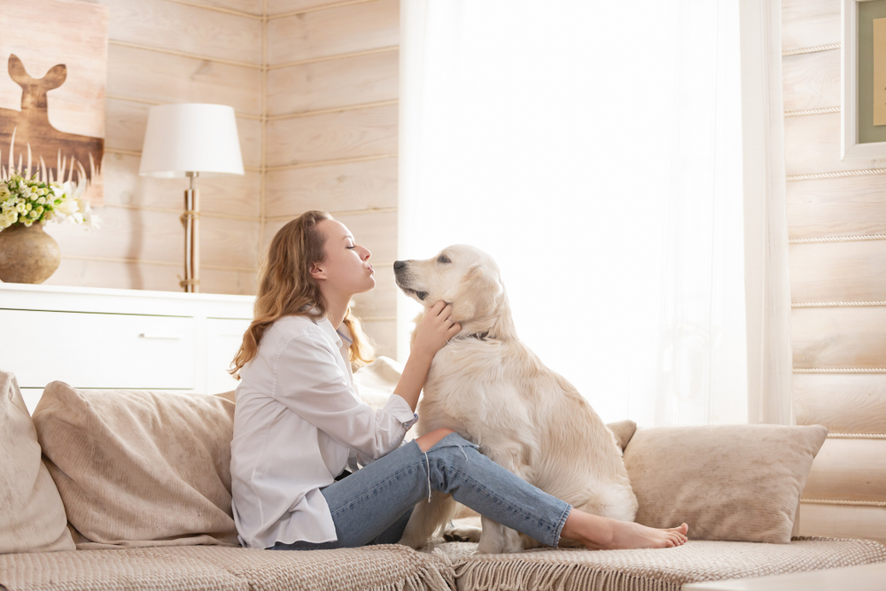 woman bonding with her dog inside